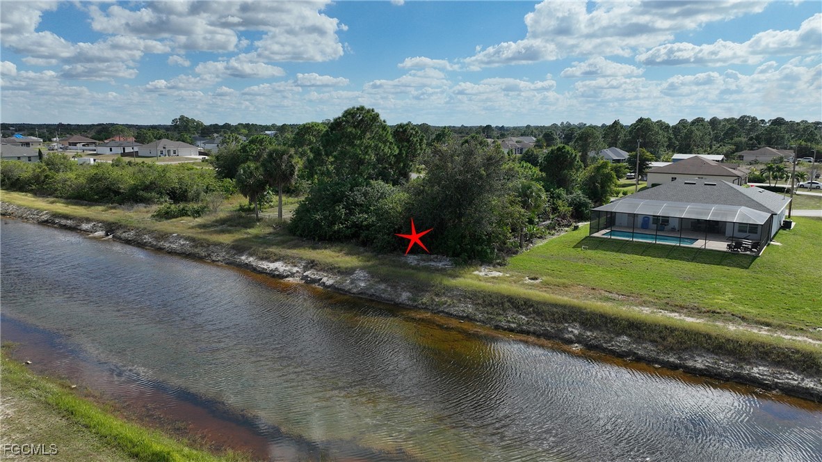 105 Paddock Street Lehigh Acres, FL 33974 - Photo 5 of 20 an aerial view of a house with a yard and lake view
