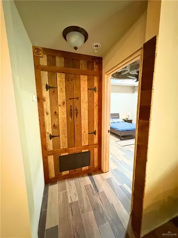 a bedroom with a bed and a dresser with wooden floor