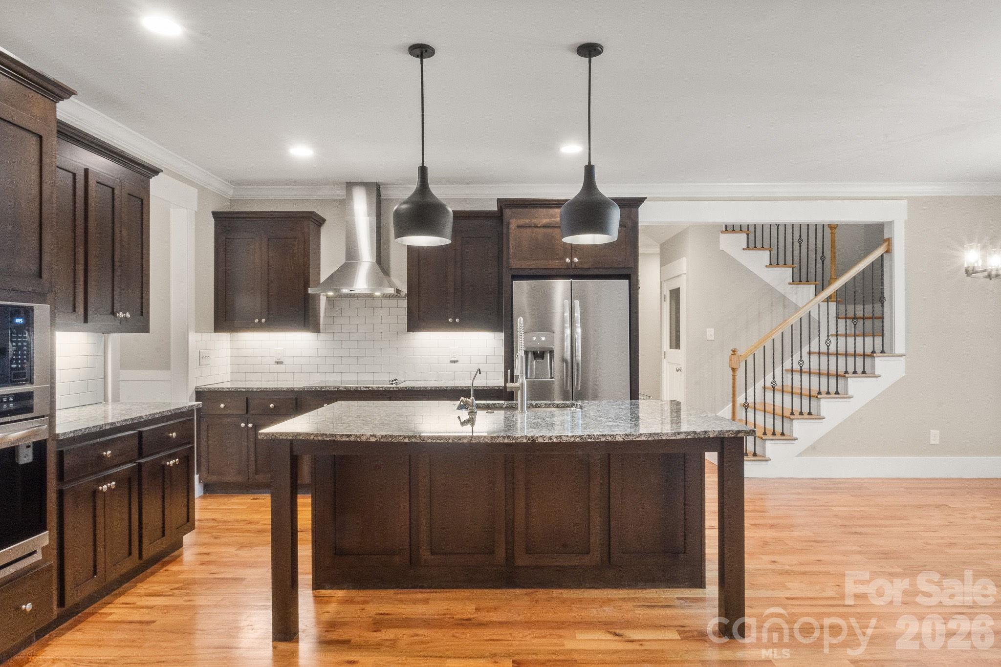 7261 Bay Ridge Drive Denver, NC 28037 - Photo 19 of 48 a kitchen with stainless steel appliances granite countertop a sink a stove and a wooden floors