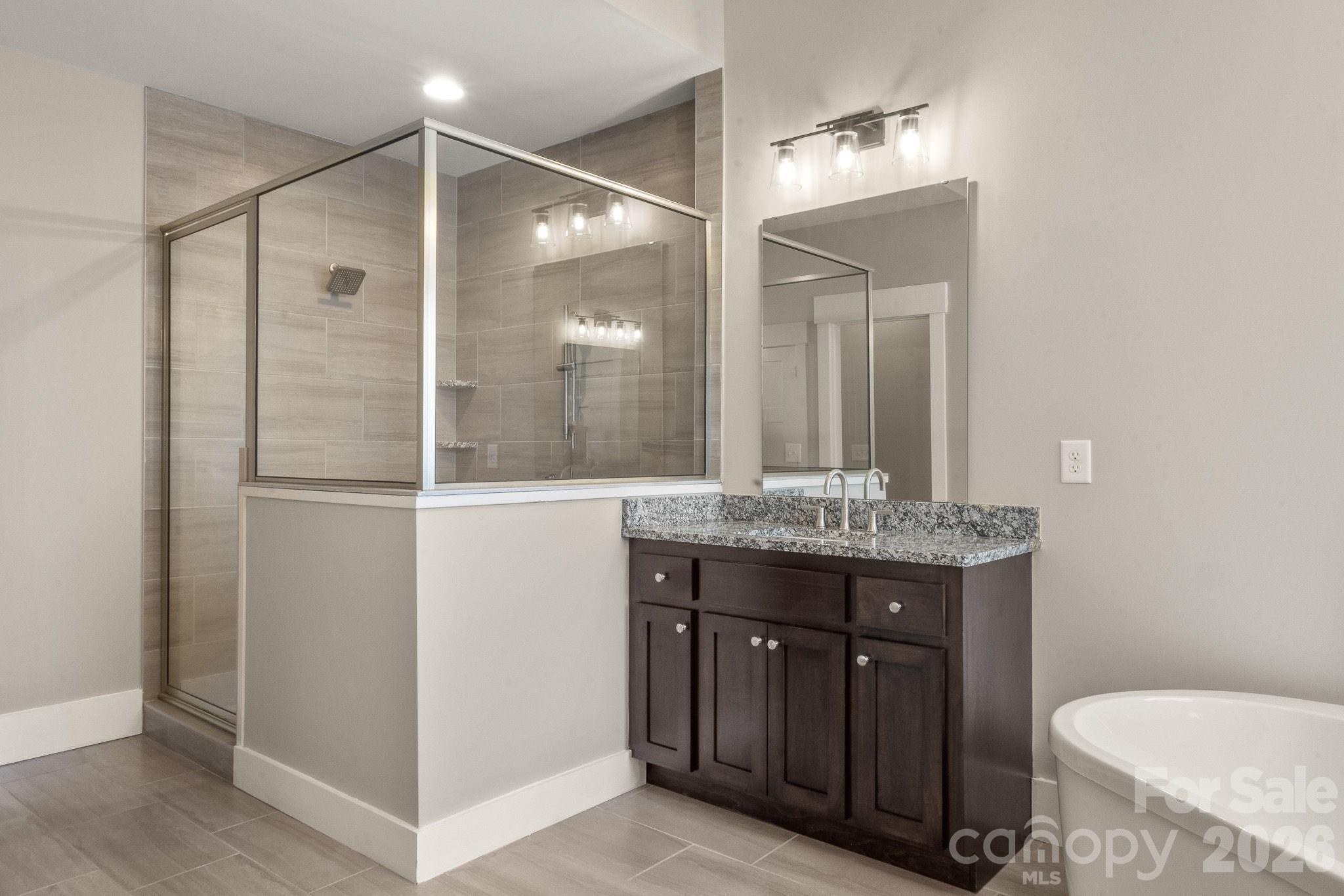 7261 Bay Ridge Drive Denver, NC 28037 - Photo 30 of 48 a bathroom with a granite countertop sink toilet a mirror and shower