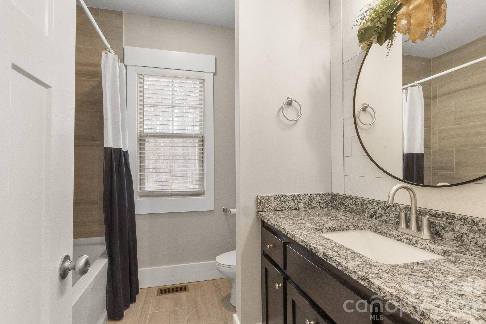 7261 Bay Ridge Drive Denver, NC 28037 - Photo 33 of 48 a bathroom with a granite countertop sink a toilet and a mirror