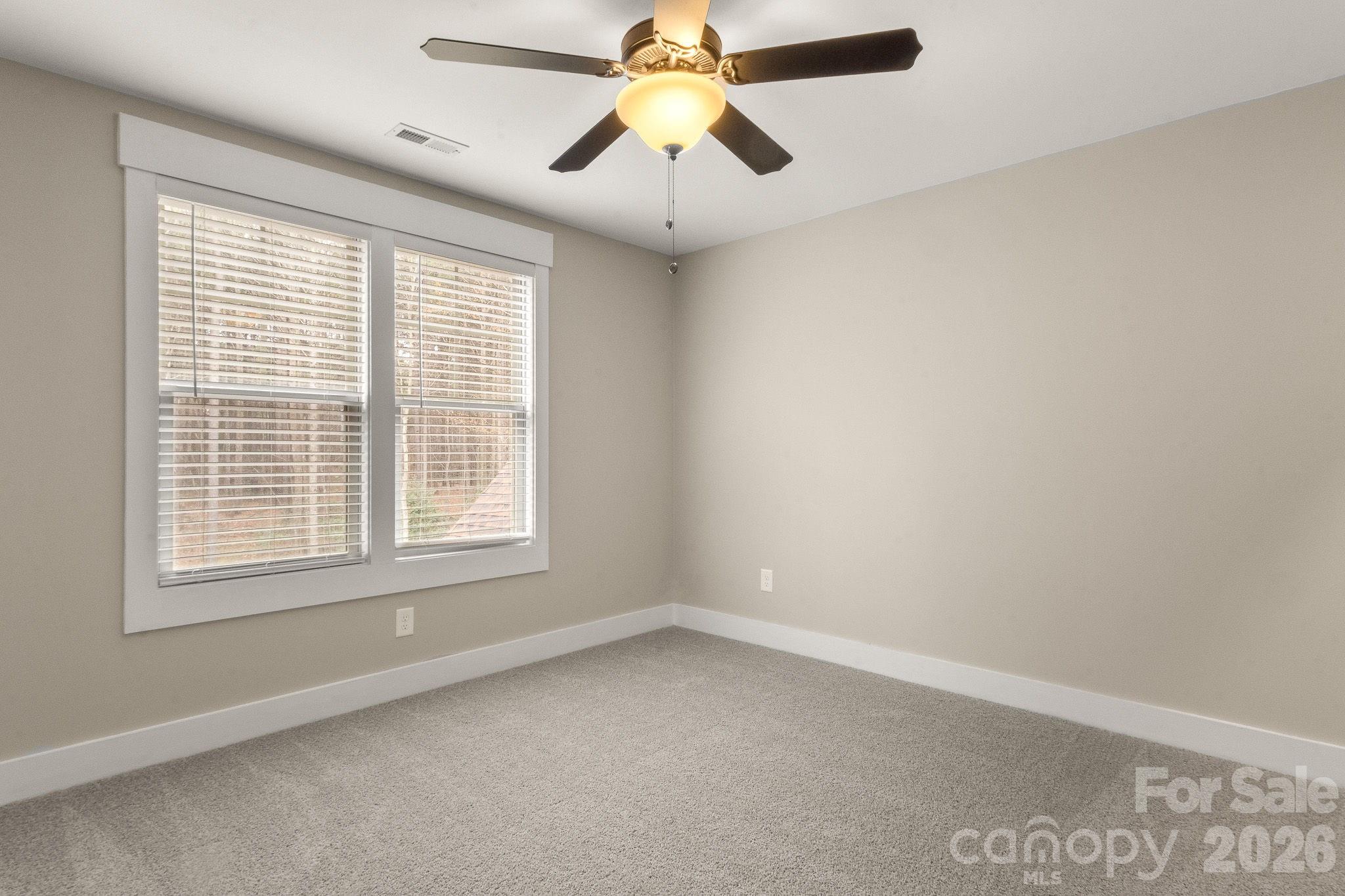7261 Bay Ridge Drive Denver, NC 28037 - Photo 42 of 48 an empty room with a window and a chandelier fan