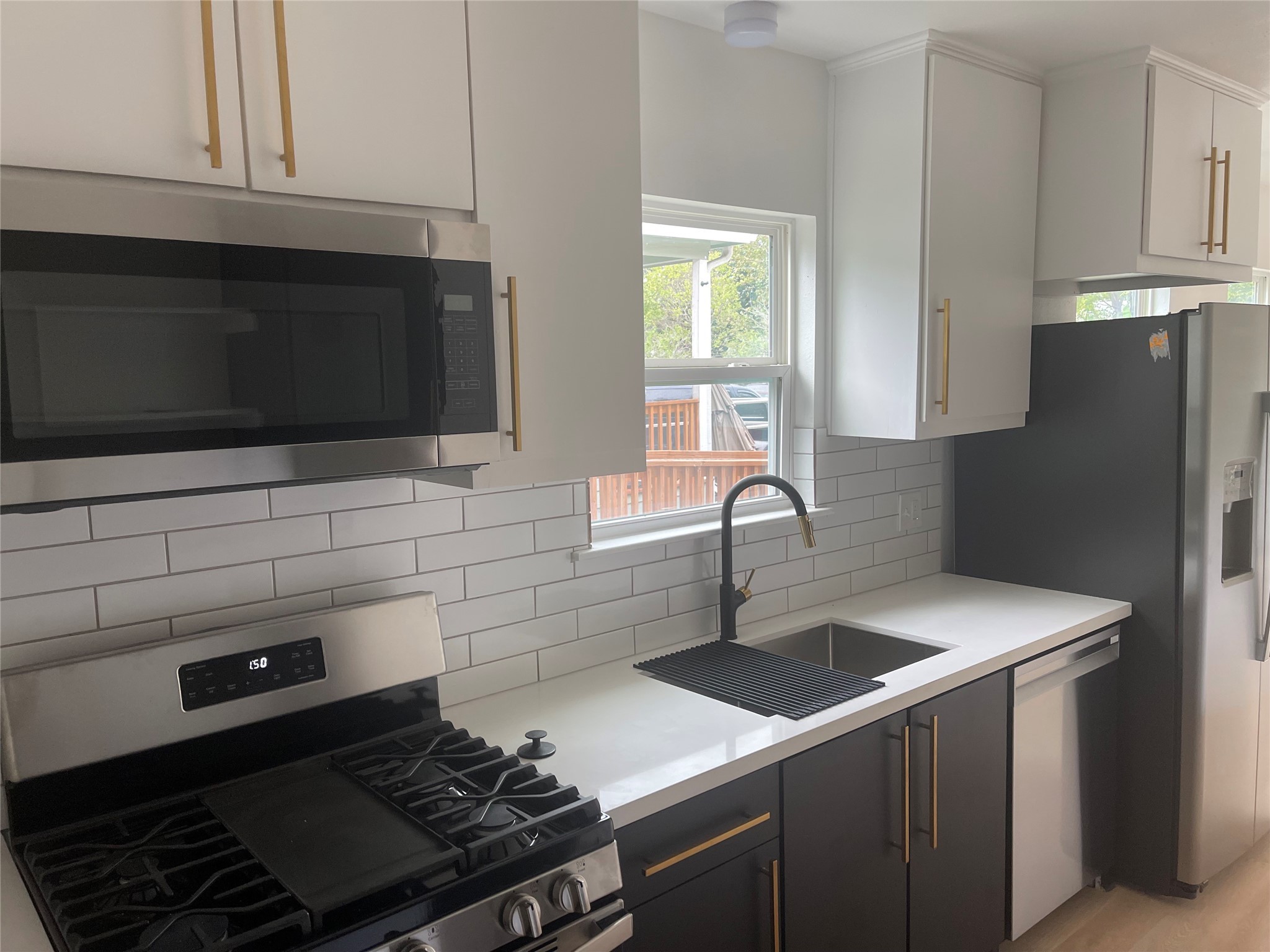 9434 Rhode Island Street Houston, TX 77029 - Photo 4 of 15 a kitchen with granite countertop a sink stove and microwave