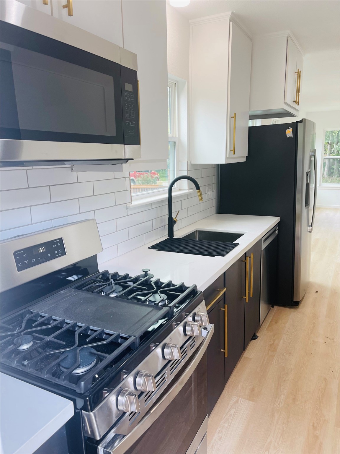 9434 Rhode Island Street Houston, TX 77029 - Photo 5 of 15 a kitchen with a stove and a microwave