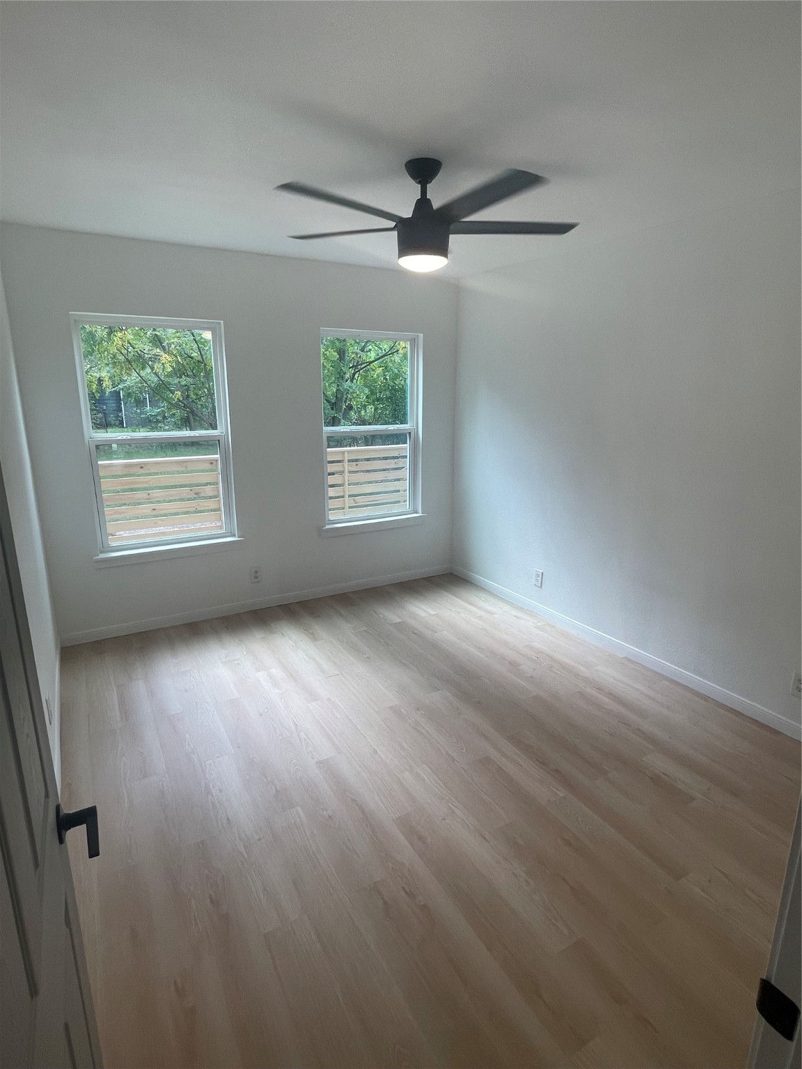 9434 Rhode Island Street Houston, TX 77029 - Photo 7 of 15 an empty room with wooden floor and windows