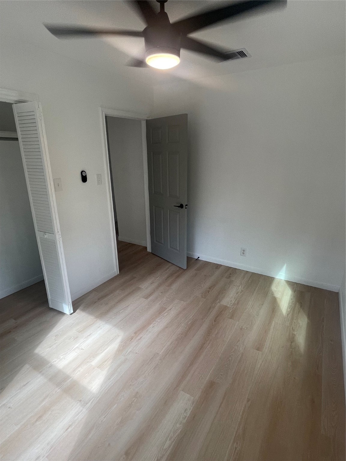 9434 Rhode Island Street Houston, TX 77029 - Photo 8 of 15 an empty room with wooden floor and windows