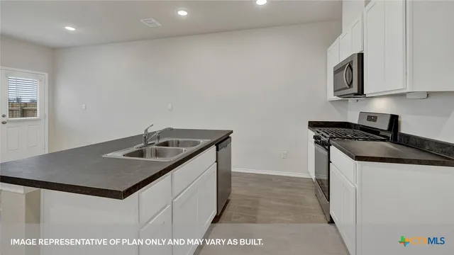 a kitchen with stainless steel appliances granite countertop a sink a stove and a refrigerator