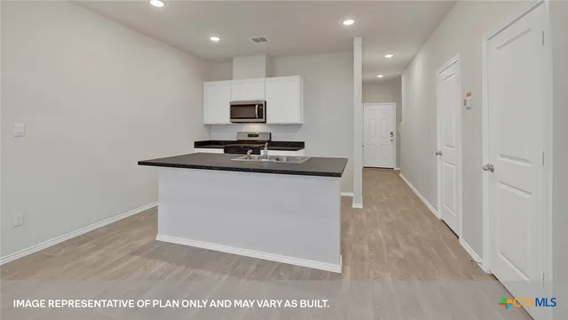 a kitchen with kitchen island sink stove and refrigerator
