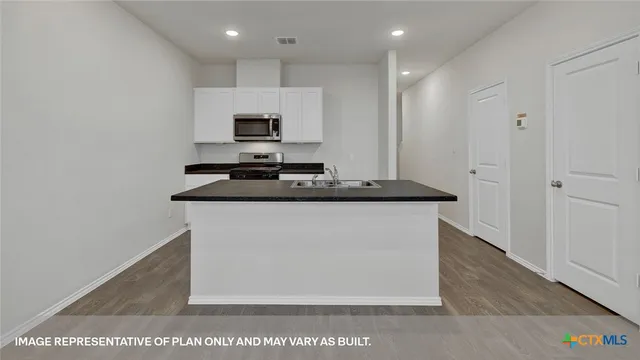 a kitchen with stainless steel appliances granite countertop a sink stove and microwave