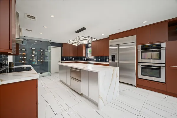 a kitchen with stainless steel appliances kitchen island granite countertop a stove and a sink