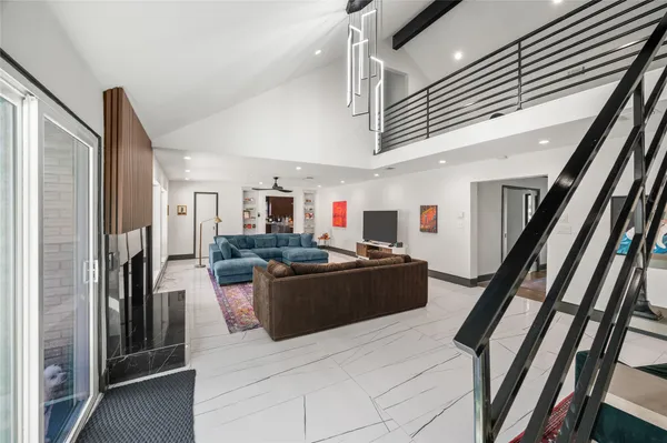 a living room with stainless steel appliances kitchen island granite countertop furniture and a refrigerator