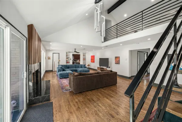 a living room with stainless steel appliances furniture fireplace and television