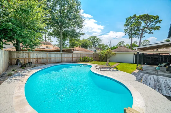 a view of a house with swimming pool and yard
