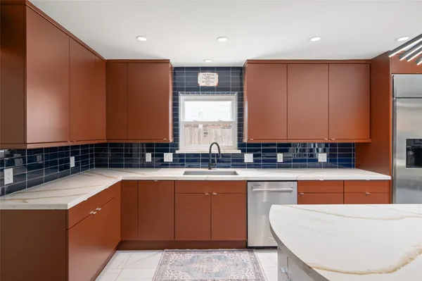 a large kitchen with stainless steel appliances granite countertop a sink and a stove