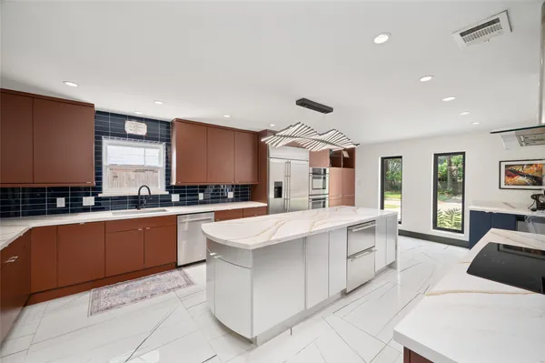 a large kitchen with stainless steel appliances kitchen island granite countertop a sink and cabinets
