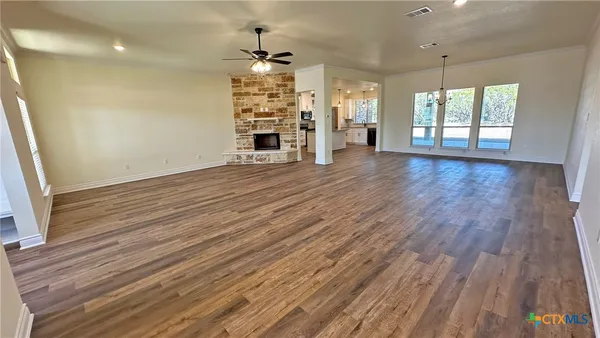 an empty room with wooden floor and chandelier