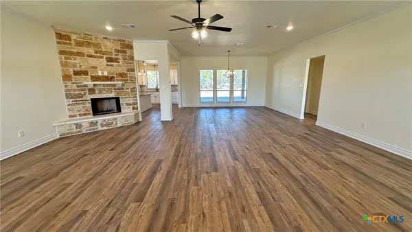 an empty room with wooden floor and fireplace