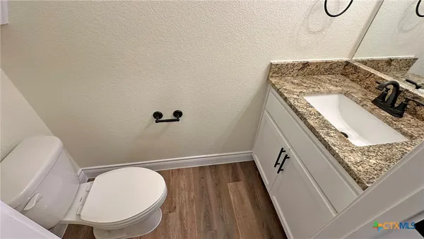 a bathroom with a granite countertop sink a mirror and shower