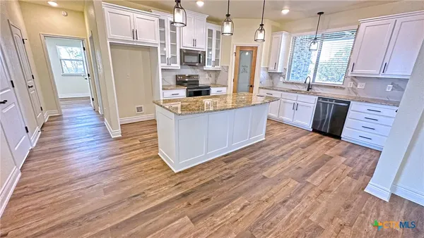 a large kitchen with a wooden floor and a large window