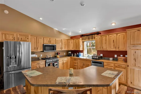 a kitchen with granite countertop a sink a counter top stainless steel appliances and cabinets