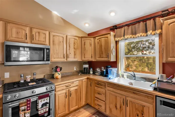a kitchen with stainless steel appliances granite countertop a stove a sink and a microwave
