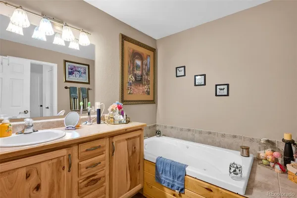 a bathroom with a tub sink and mirror