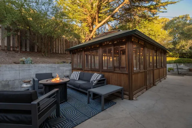 a backyard of a house with barbeque oven table and chairs