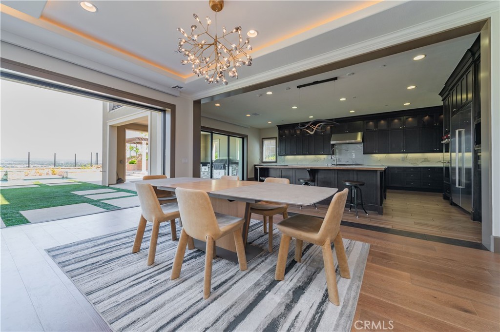 122 Scenic Crest Irvine, CA 92618 - Photo 14 of 68 a dining room with wooden floor a chandelier a wooden table and chairs