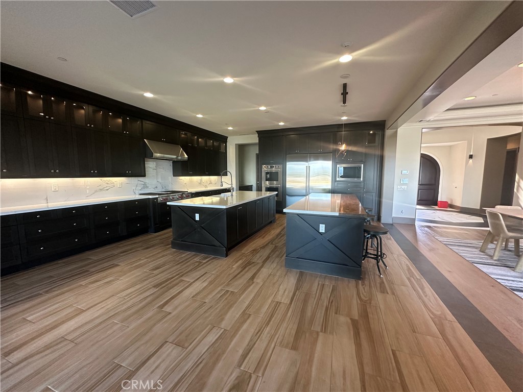 122 Scenic Crest Irvine, CA 92618 - Photo 21 of 68 a large kitchen with stainless steel appliances a large counter top a stove and a wooden floors