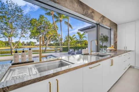 a kitchen with stainless steel appliances kitchen island granite countertop a table and chairs in it