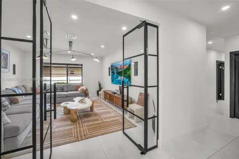 a spacious bedroom with a bed a couch and a flat tv screen on dresser