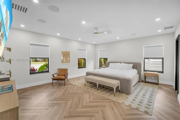 a large kitchen with stainless steel appliances kitchen island a large counter top a sink and a refrigerator