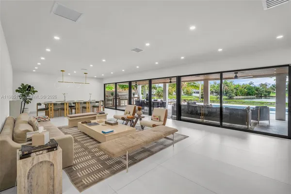 a living room with furniture large windows and a table