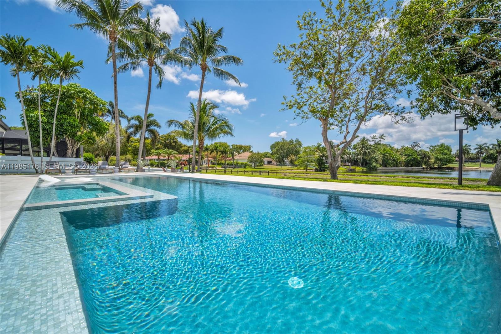 4430 Casper Court Hollywood, FL 33021 - Photo 48 of 64 a view of a swimming pool with a yard and palm trees