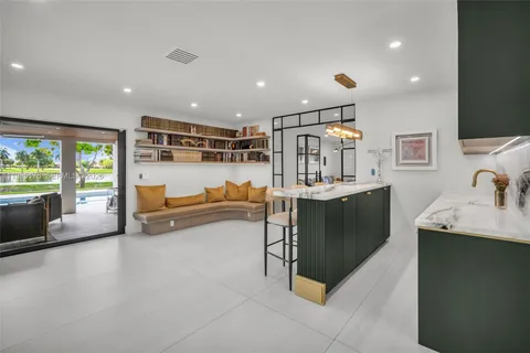 a living room with stainless steel appliances furniture and a kitchen view