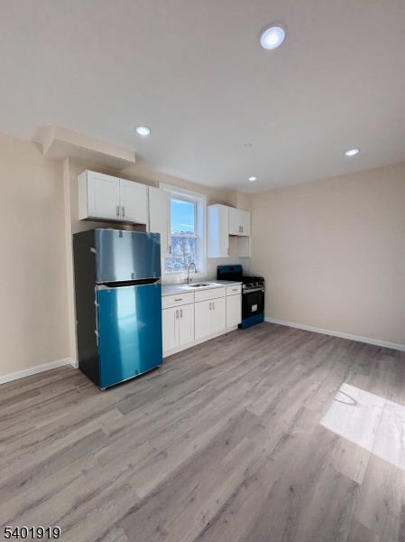 59 Cedar Street, Unit 303 Paterson, NJ 07501 - Photo 4 of 10 a kitchen with a refrigerator and a stove top oven