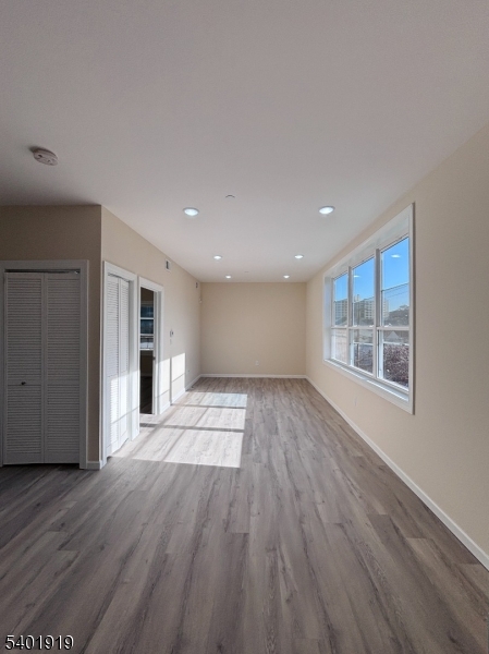 59 Cedar Street, Unit 303 Paterson, NJ 07501 - Photo 6 of 10 a view of an empty room with wooden floor and a window
