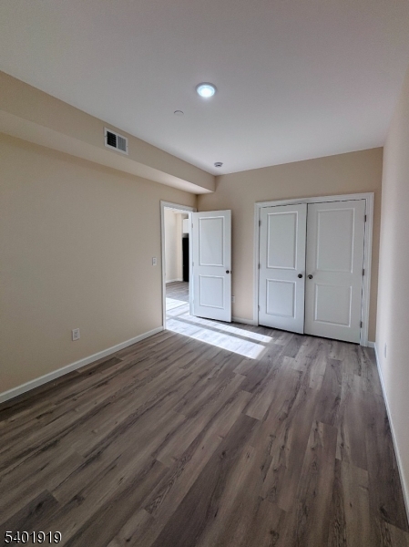 59 Cedar Street, Unit 303 Paterson, NJ 07501 - Photo 7 of 10 a view of an empty room with wooden floor and closet
