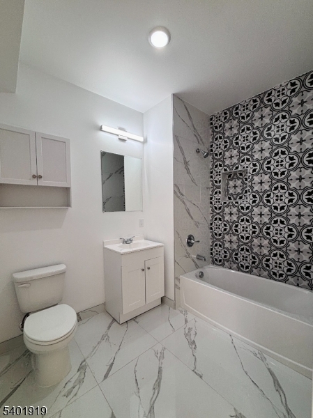 59 Cedar Street, Unit 303 Paterson, NJ 07501 - Photo 8 of 10 a bathroom with a toilet a sink and bathtub