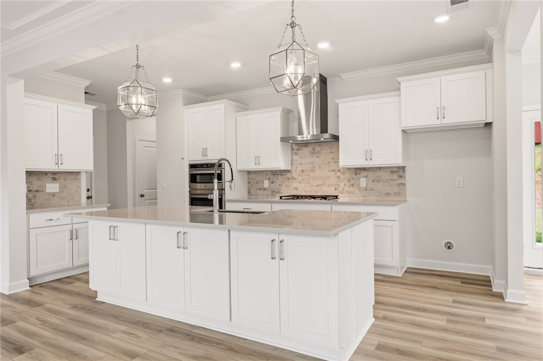 This spacious kitchen offers a large island, bright cabinetry, and stylish fixtures for contemporary living.