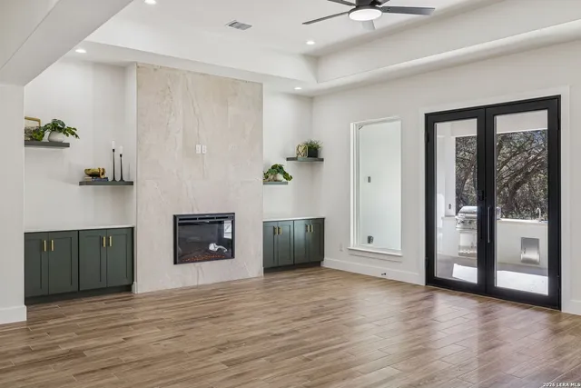 a kitchen with granite countertop white cabinets stainless steel appliances and wooden floor