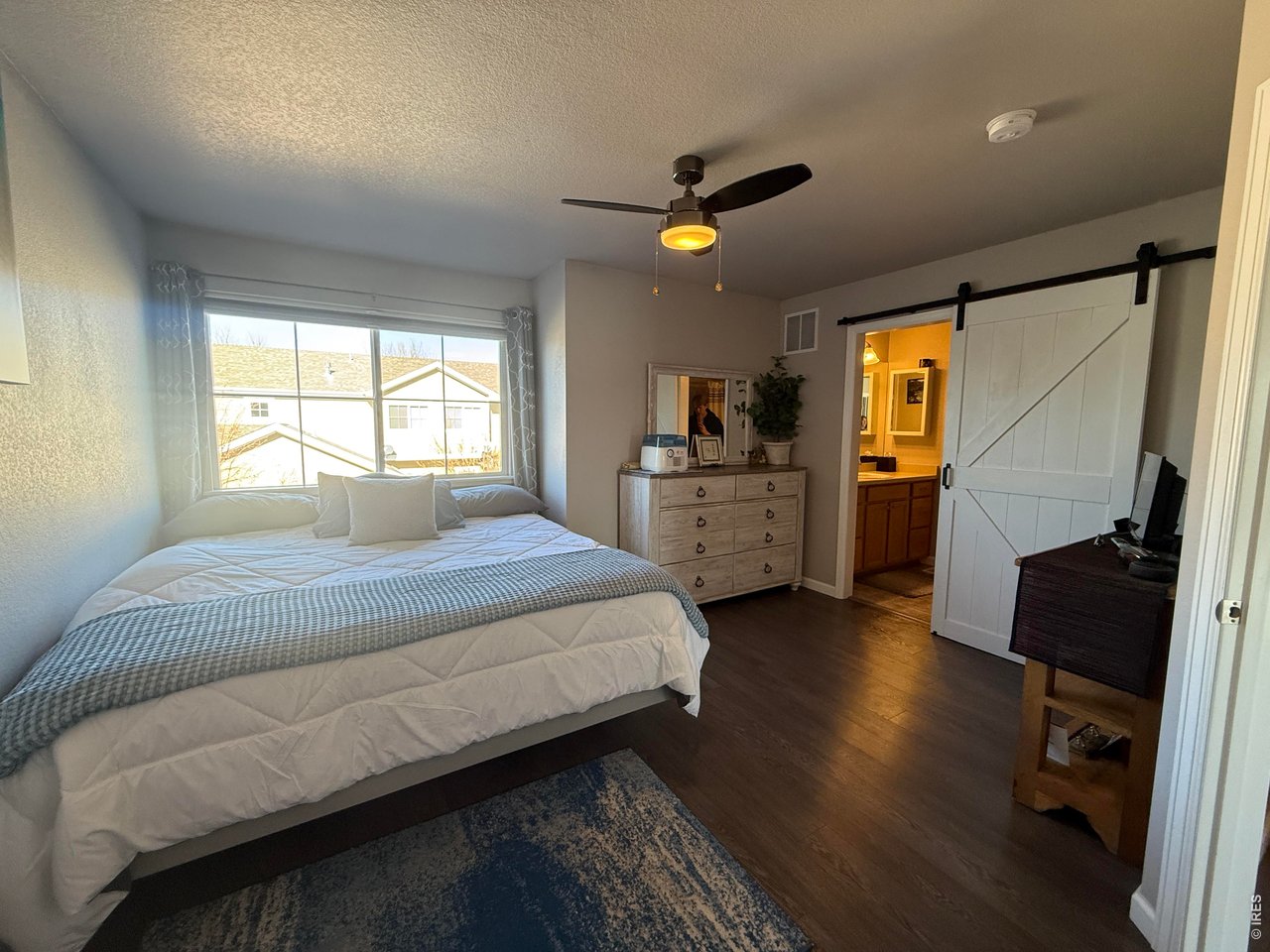 810 Gentlewind Way Berthoud, CO 80513 - Photo 13 of 35 primary bedroom with room for a King bed, several dressers. Barn door into primary bath