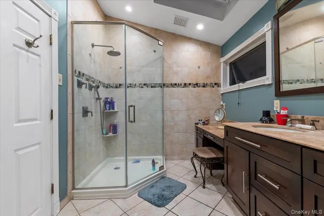a bathroom with a shower sink and mirror