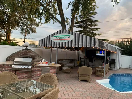 a roof deck with table and chairs and potted plants