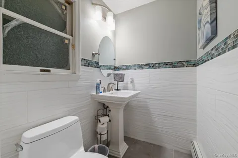 a bathroom with a sink a toilet and mirror