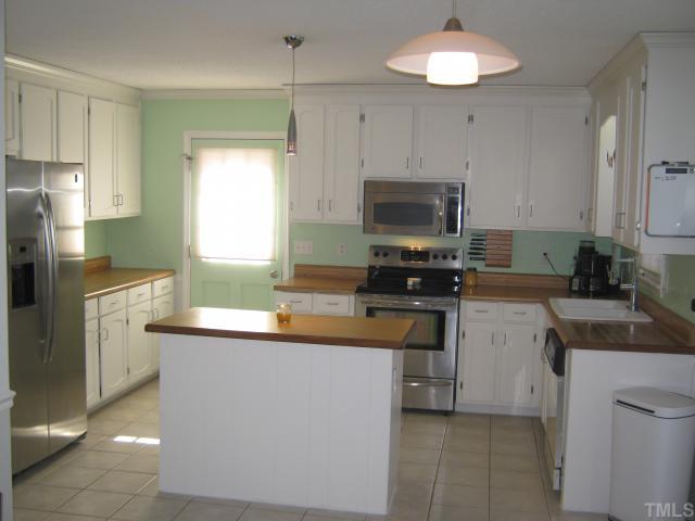 3401 Cartway Lane Raleigh, NC 27616 - Photo 2 of 12 Nice Size Kitchen with Tile Floor, Island, Plenty of Cabinet Space, Stainless Steel Microwave, with Brand New Stove,