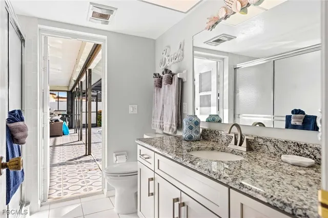 a bathroom with a granite countertop sink toilet and shower