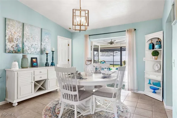 a dining room with furniture a chandelier and kitchen view