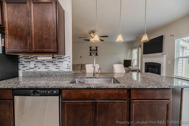 a kitchen with kitchen island granite countertop a sink a counter top space appliances and cabinets