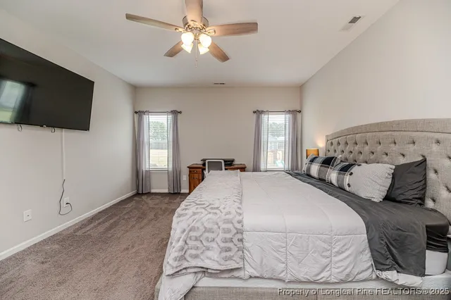 a bedroom with a large bed and a flat screen tv